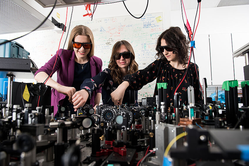 A group of women working at an optical workbench.