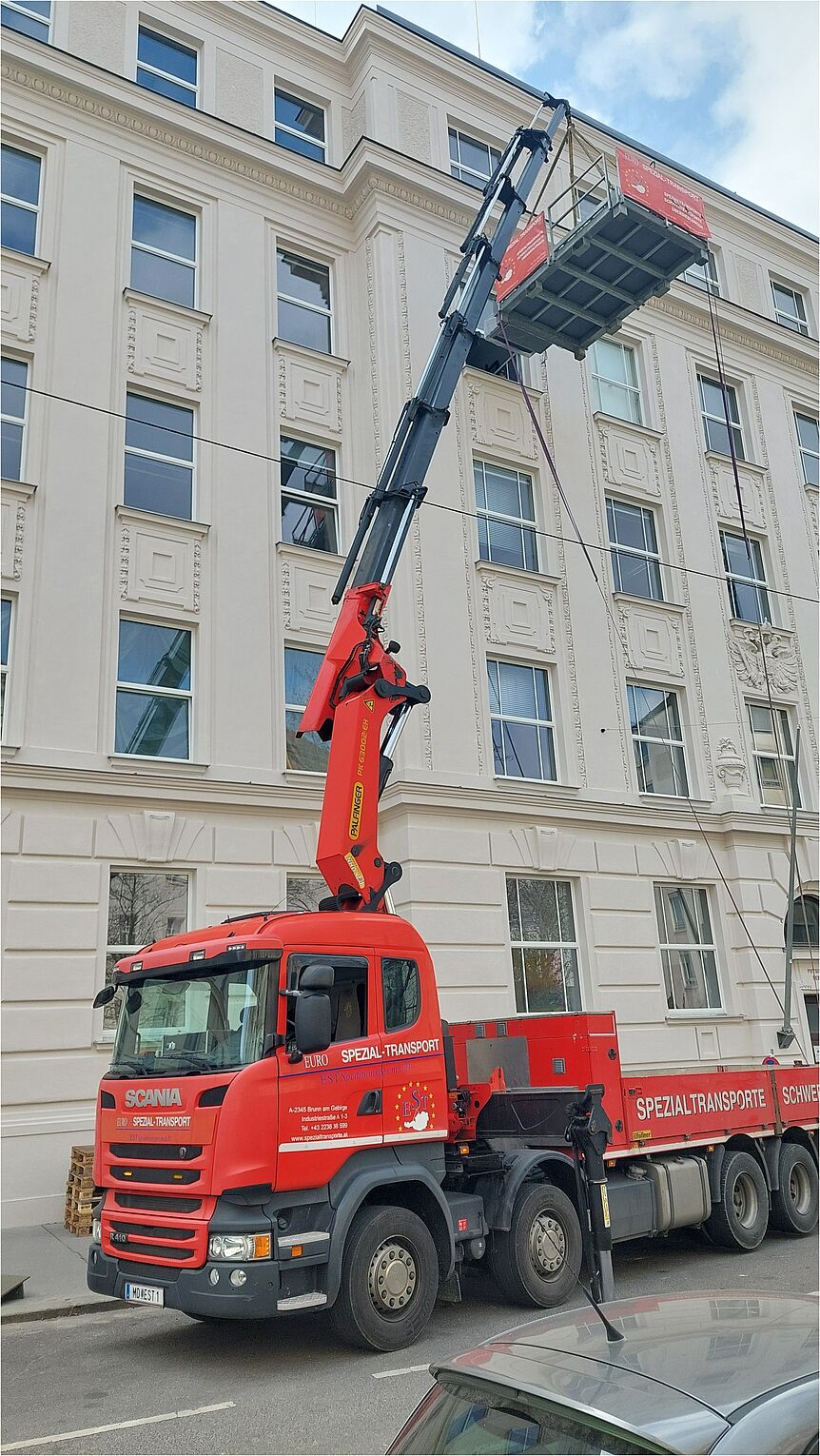 The vehicle for heavy haulage lifting the desk with its crane.