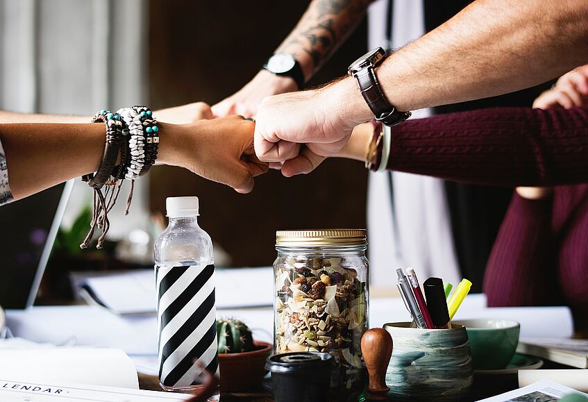 People putting their fists together as a gesture of teamwork.